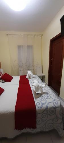 a bedroom with a bed with a red and white blanket at Pensión Mar in Portomarin