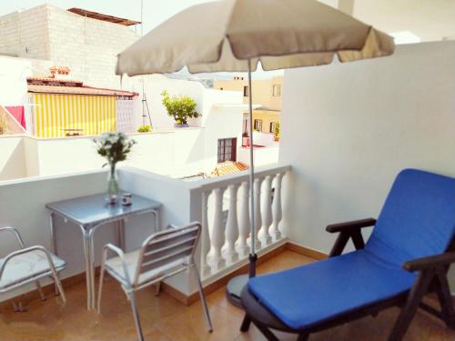 balcón con mesa, sillas y sombrilla en Casa Atlantica en Alcalá