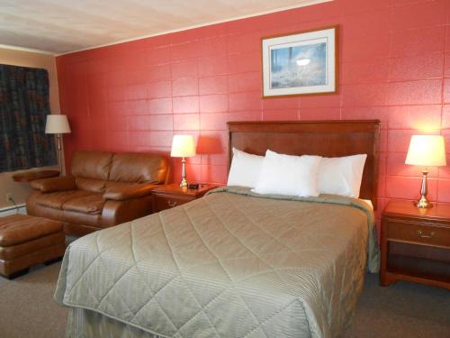a hotel room with a bed and a chair at Aquarius Motel in Perth