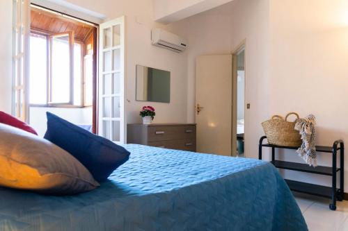 Un dormitorio con una cama con almohadas azules. en Casa Pitea, en Mondello