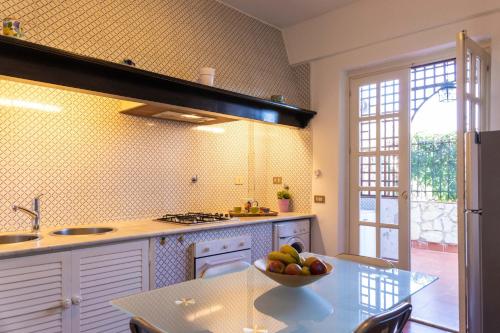 Una cocina con un bol de fruta en una mesa. en Casa Pitea, en Mondello