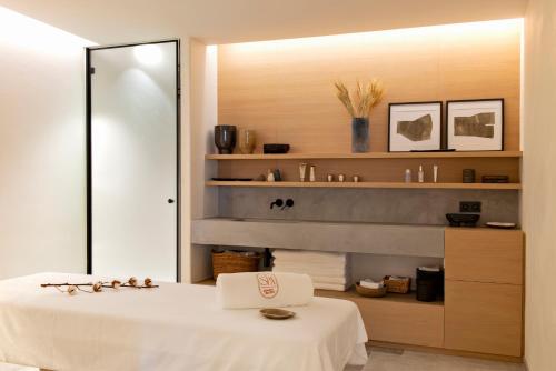 a bathroom with a white bed and a mirror at Auberge Du Père Bise - Jean Sulpice in Talloires