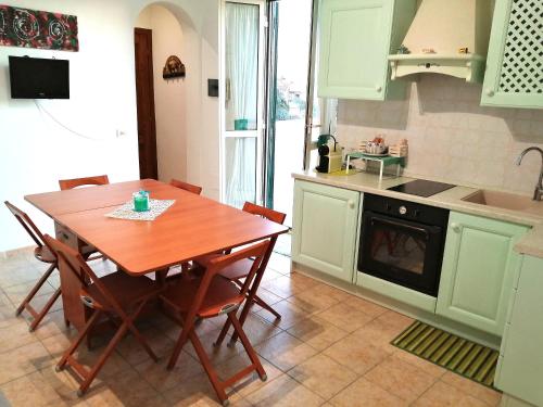 a kitchen with a wooden table and a table and chairs at Casetta la Terrazza in Civita Castellana