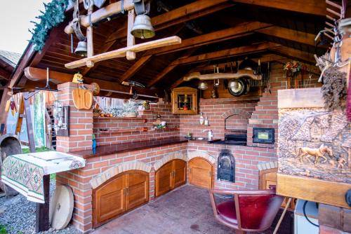 a kitchen with a brick wall with a stove at Pensiunea Curtea lui Toader in Simioneşti
