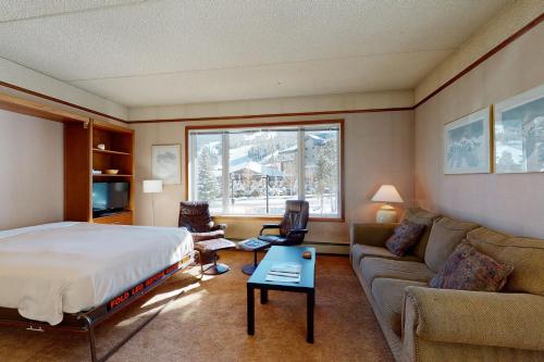 a hotel room with a bed and a couch at Telemark in Copper Mountain