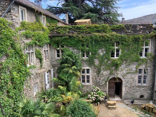 Saint-Étienne-Vallée-FrançaiseにあるLe Château de Cambiaireの蔦の古石造りの家