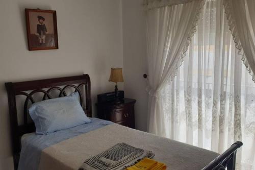 1 dormitorio con cama y ventana en A Casa da Avo Dina, en Fuseta