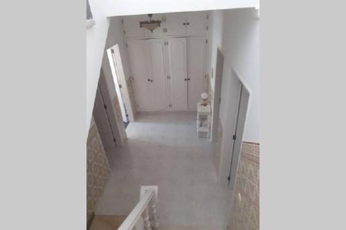 um corredor vazio com uma escada numa casa em A Casa da Avo Dina em Fuzeta