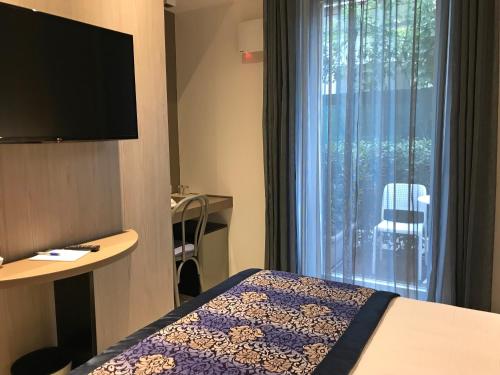 um quarto de hotel com uma cama e uma janela em Hotel Villa Hermosa em Riccione