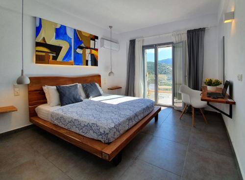 a bedroom with a bed and a desk and a window at Villa Albatross in Sivota