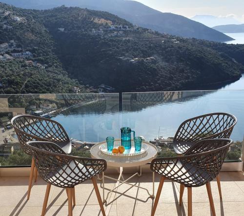 a table and chairs on a balcony with a view of the water at Villa Albatross in Sivota