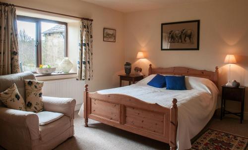 a bedroom with a bed and a chair and a window at Loadbrook Cottages in Sheffield
