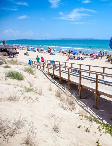 a beach with a bunch of people on the sand at La Marina Resort in La Marina
