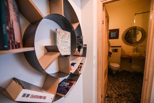 Habitación con estante para libros y baño. en Casa Agora, en Cisnădioara