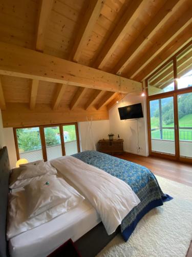 a bedroom with a large bed in a room with windows at Kurzzeitdomizil in Oberstdorf in Oberstdorf