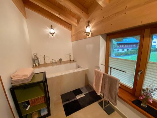 La salle de bains est pourvue d'une baignoire et d'une fenêtre. dans l'établissement Kurzzeitdomizil in Oberstdorf, à Oberstdorf