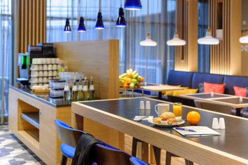 a restaurant with a table with a plate of food on it at Holiday Inn Express - Berlin - Alexanderplatz by IHG in Berlin
