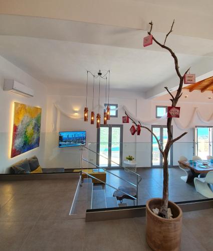 a living room with a tree in a pot at Villa Albatross in Sivota
