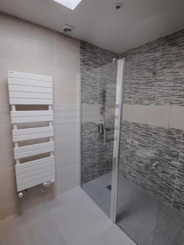 a bathroom with a shower with a glass door at Superbe chambre de charme avec accès privatif in Houilles