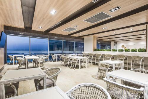 a restaurant with tables and chairs and a view of the ocean at Holiday Inn Express - Barranquilla Buenavista by IHG in Barranquilla