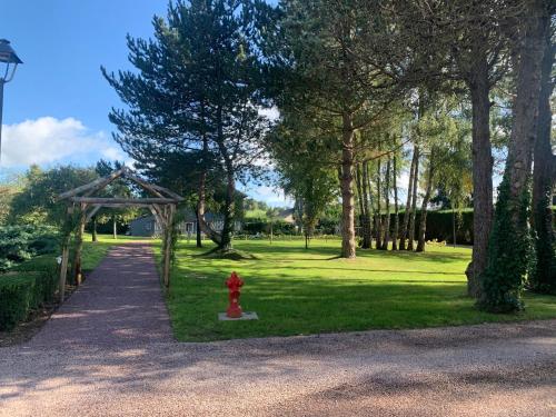 a red fire hydrant in the middle of a park at Les Manoirs des Portes de Deauville - Small Luxury Hotel Of The World in Deauville