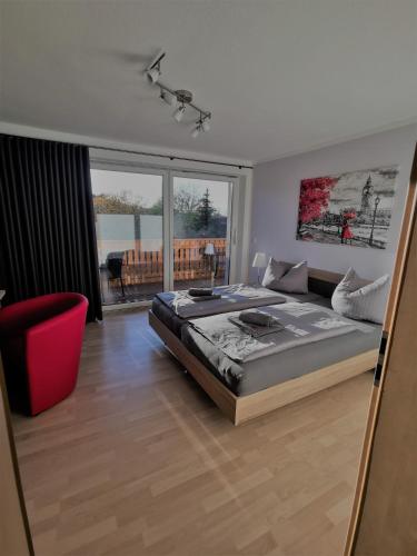 Un dormitorio con una cama grande y una silla roja. en Ferienwohnung Hofmeister, en Heilbad Heiligenstadt