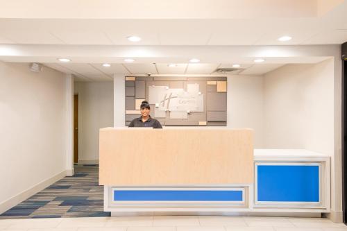 a man standing behind a counter in an office at Holiday Inn Express Atlanta-Stone Mountain by IHG in Stone Mountain