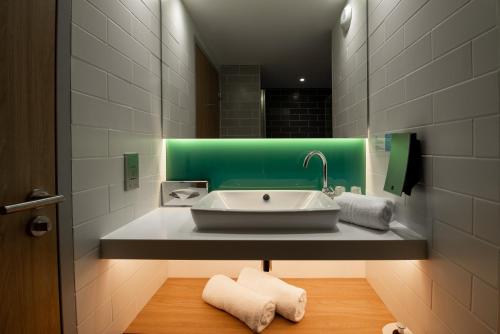 a bathroom with a sink and a green at Holiday Inn Express - Arcachon - La Teste by IHG in La Teste-de-Buch