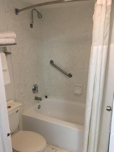 a bathroom with a tub and a toilet and a shower at Days Inn by Wyndham Stuart in Stuart