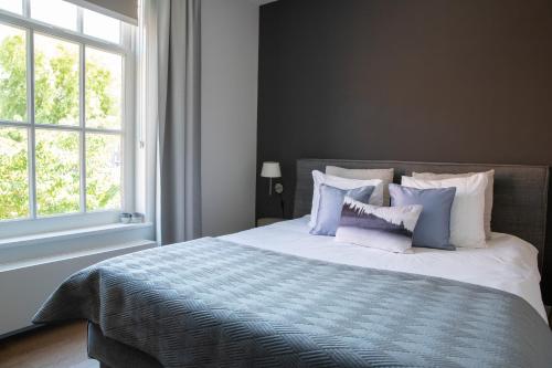 una camera da letto con un letto con cuscini blu e bianchi di Bed & Breakfast Monument076 Etten-Leur a Etten-Leur