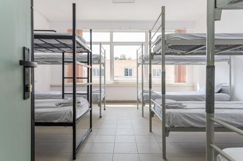 a room with four bunk beds and a window at Hostel Ghimbav Airport in Ghimbav