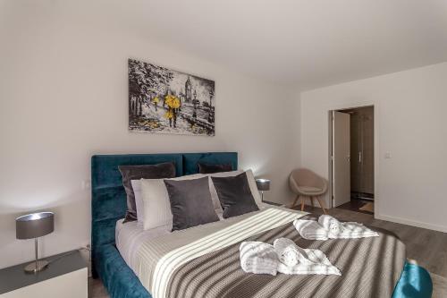 een slaapkamer met een bed met een blauw hoofdeinde bij LED Apartment - Vista Alegre in Ponte de Lima