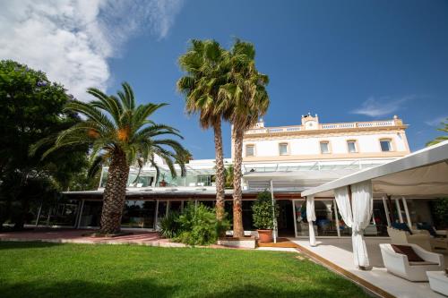 a resort with palm trees and a building at Tancat de Codorniu in Les Cases d'Alcanar