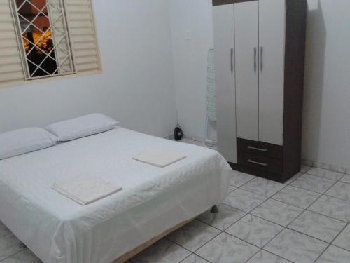 um quarto com uma cama, um armário e uma janela em Nosso Lar casa inteira, completa e independente em Barra do Garças