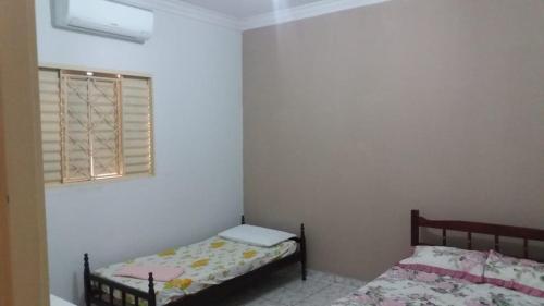 a bedroom with two beds and a window at Nosso Lar casa inteira, completa e independente in Barra do Garças