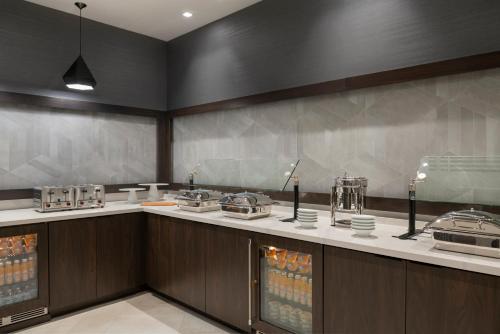 a kitchen with a counter with food and drinks at Holiday Inn Express - Boston Logan Airport - Revere by IHG in Revere