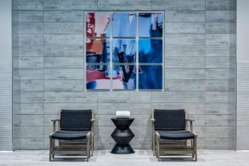 two chairs and a vase in front of a wall at Holiday Inn Express - Boston Logan Airport - Revere by IHG in Revere