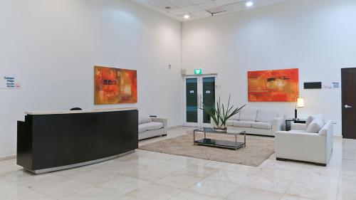 a lobby with couches and a tv in a room at Holiday Inn Express Ciudad Del Carmen by IHG in Ciudad del Carmen
