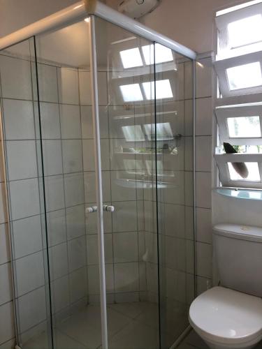 a bathroom with a glass shower with a toilet at Casa Praia da Vila in Ilhabela