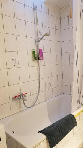 a bathroom with a tub with a shower at Wanderoase in Melsbach