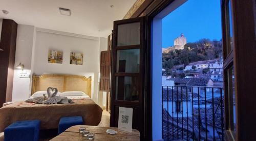 1 dormitorio con cama y vistas a la ciudad en Casa Mirador Alhambra en Granada