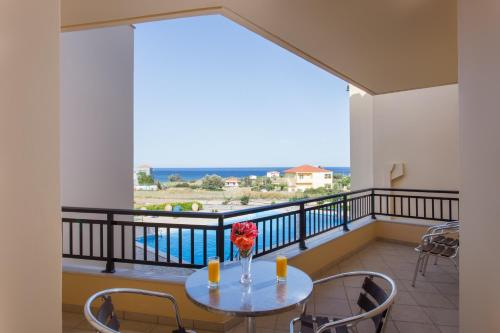a balcony with a table with a vase of flowers at Apartments Hotel & Studios, Xifoupolis in Monemvasia