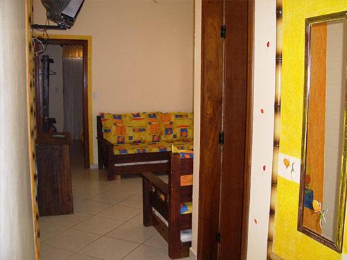 a living room with a couch and a table at Peruíbe Suíte Flat Hotel in Peruíbe