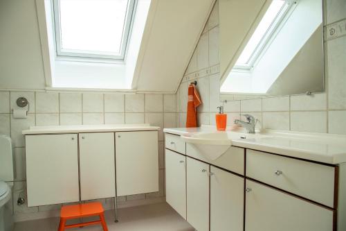 a bathroom with a sink and a mirror and a window at Anettes Bed & Breakfast Falster in Eskilstrup