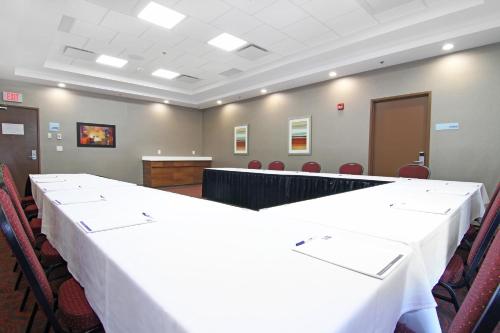 a large meeting room with a table and chairs at Holiday Inn Express and Suites Calgary University by IHG in Calgary