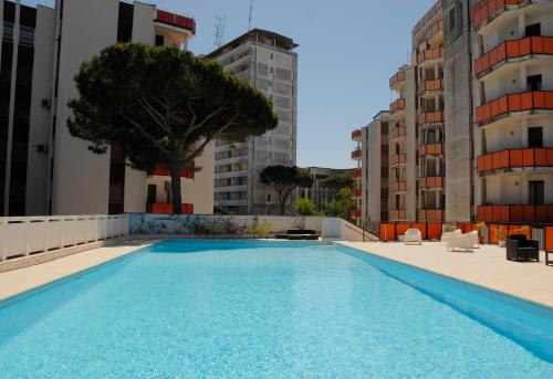 a swimming pool in the middle of some buildings at Tropicana Residence in Lido degli Estensi