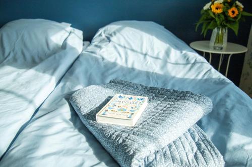 a book on a blanket on a bed with a table at Anettes Bed & Breakfast Falster in Eskilstrup