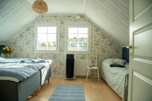 a attic bedroom with a bed and a chair at Anettes Bed & Breakfast Falster in Eskilstrup
