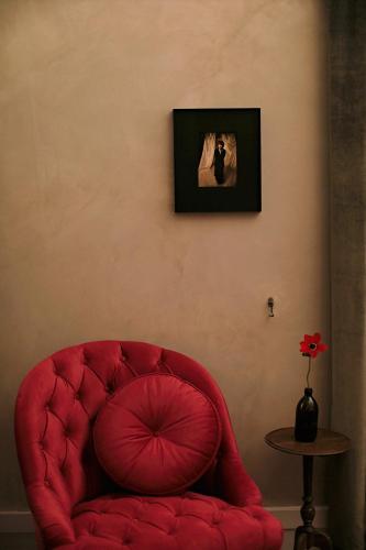 a red chair in a room with a picture on the wall at Shila Athens in Athens
