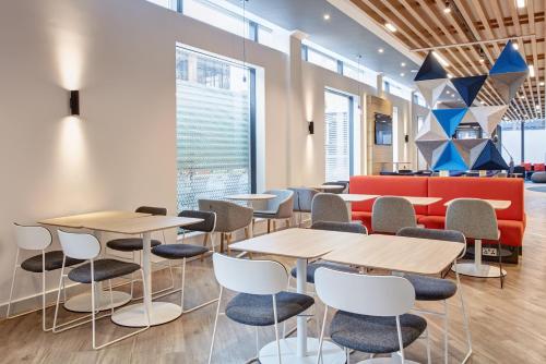 a room with tables and chairs and a couch at Holiday Inn Express Dublin City Centre by IHG in Dublin